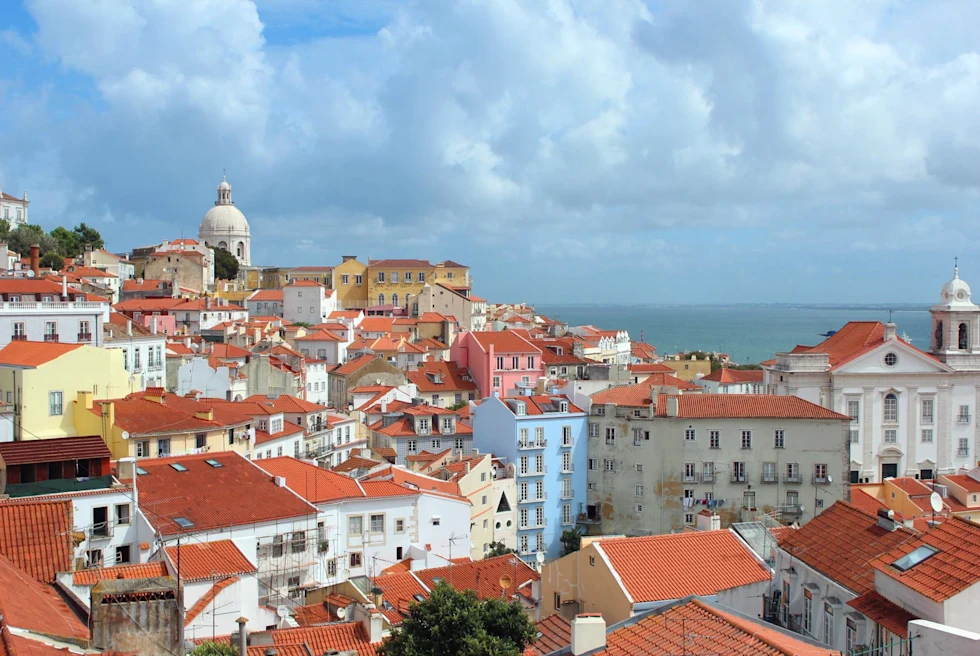 view of red rooftops of multicolored houses on a sunny day in a seaside city