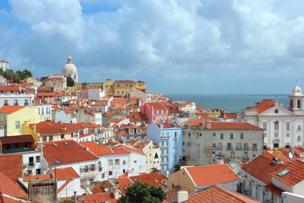 view of red rooftops of multicolored houses on a sunny day in a seaside city