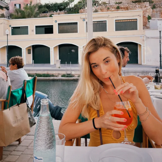 Travel Advisor Julia Lescarbeau along a canal drinking a beverage while sitting at a table.