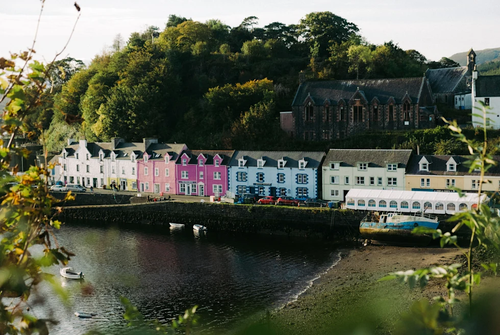 colorful houses next to a body of water with cloudy skies