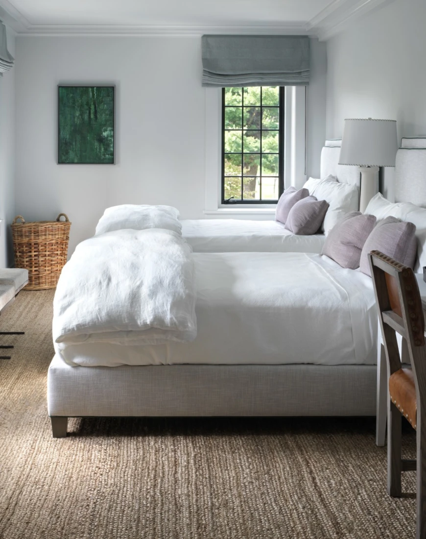 two white beds in a chic room with a tan rug