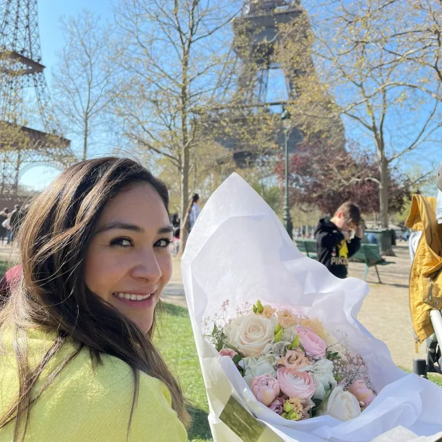 Travel advisor Alexis Castellano posing with flowers bouquet and wearing yellow shirt. 