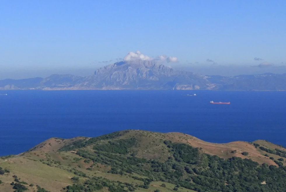 Body of water with mountains in the distance during daytime