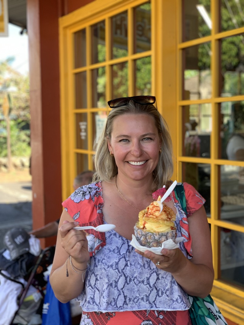 Woman holding pineapple filled with shave ice during daytime