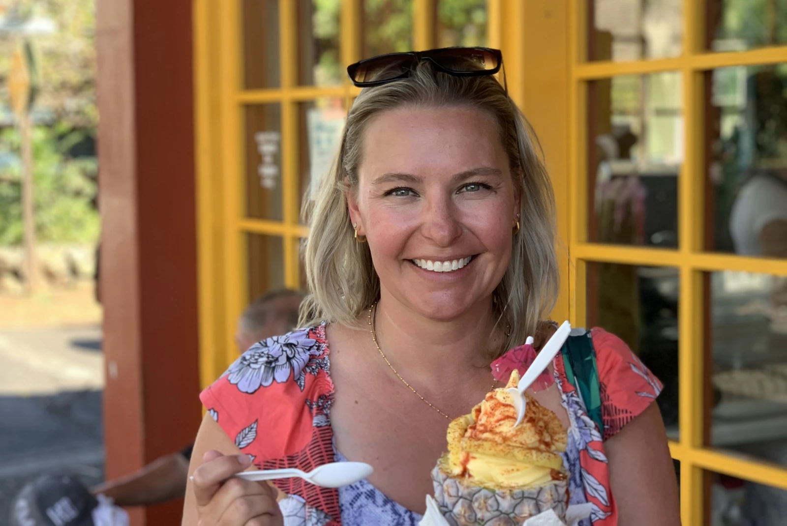 Woman holding pineapple filled with shave ice during daytime