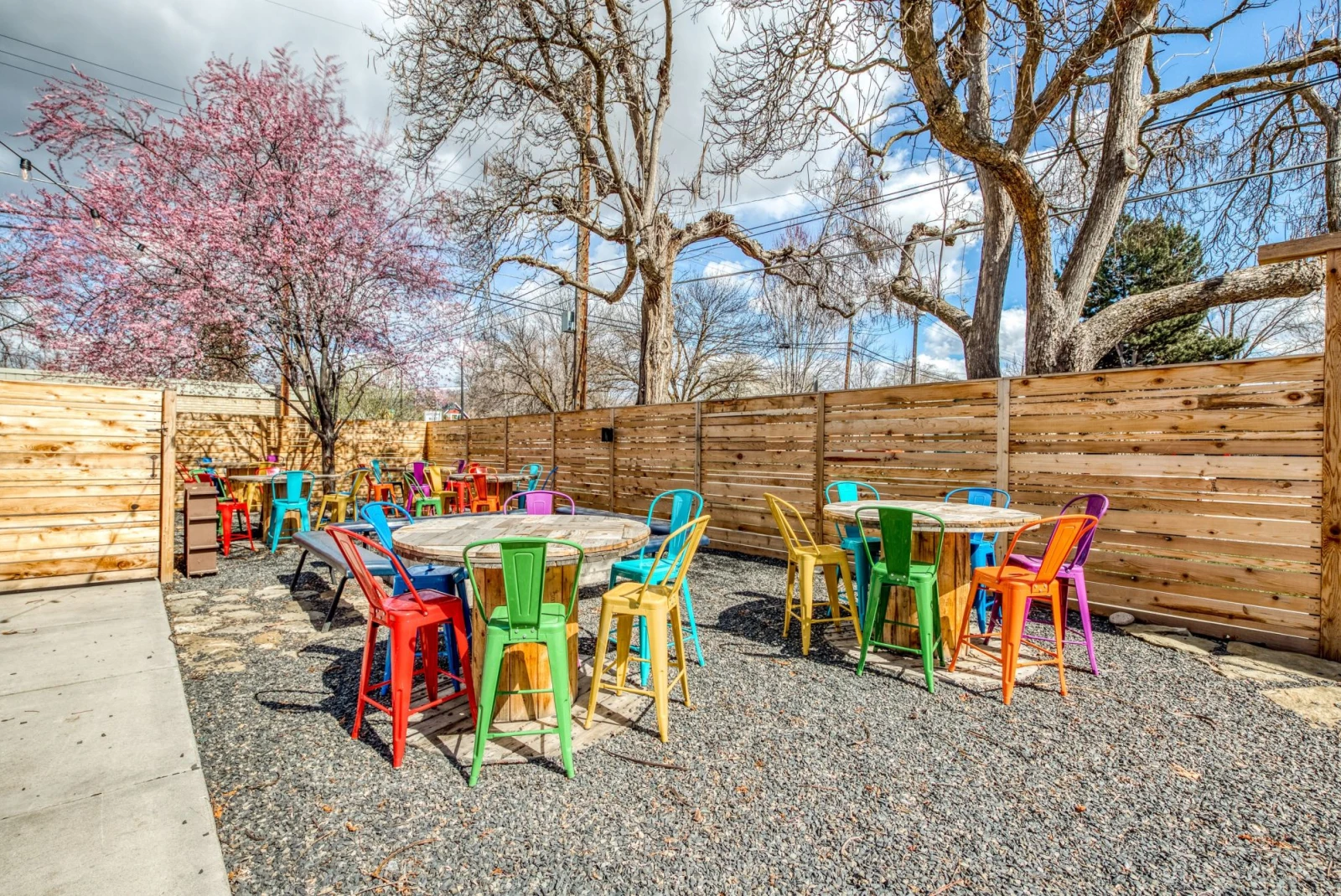 colorful chairs around wooden tables at outdoor restaurant