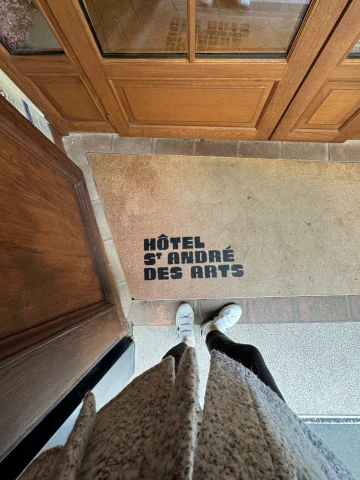 A photo of the entrance to St Andre Des Arts, one of the best hotels in St. Germain Paris, from above looking down at the entry mat.