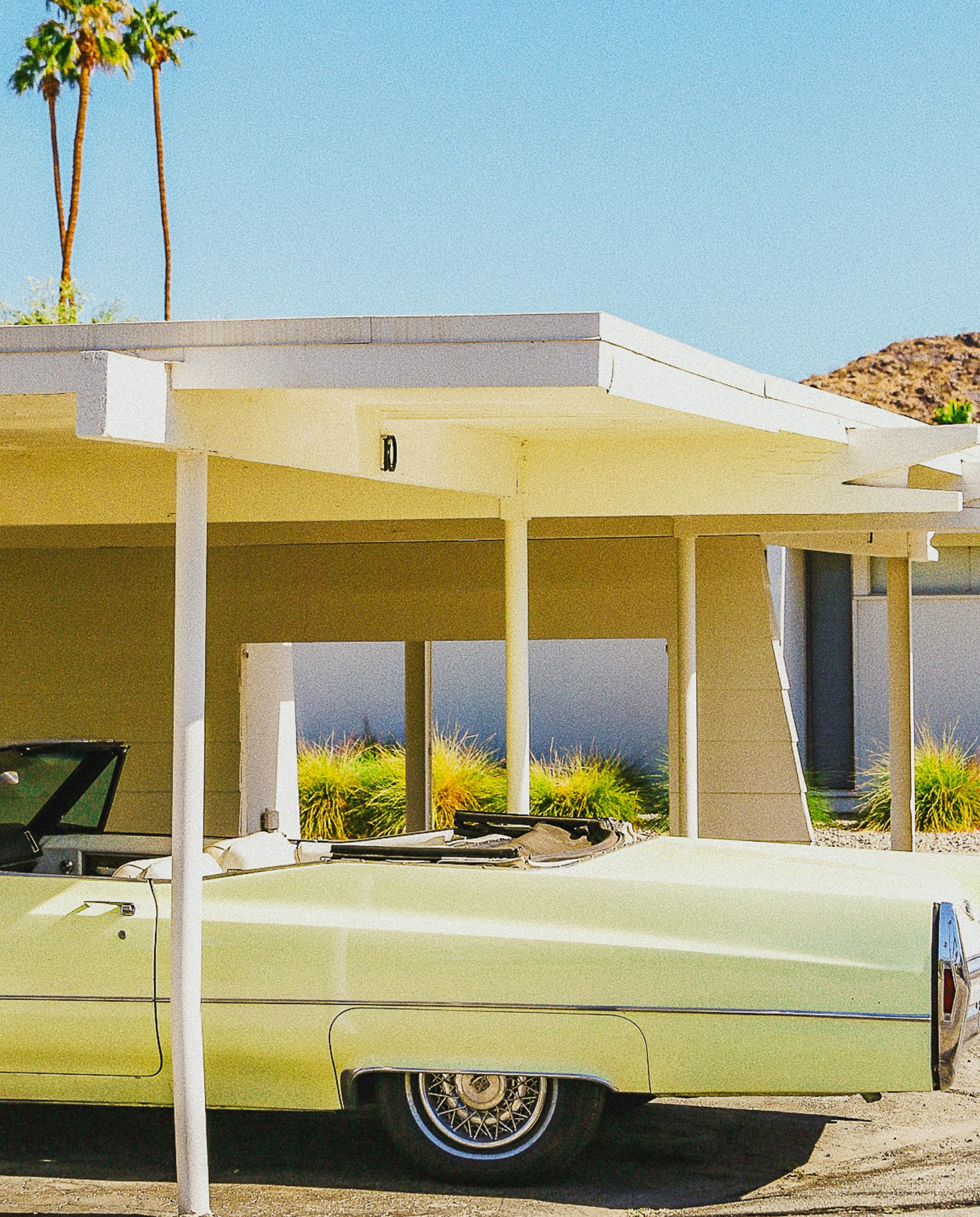 Yellow mid-century house and lime green vintage car in Palm Springs. 