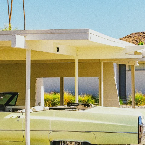 Yellow mid-century house and lime green vintage car in Palm Springs. 