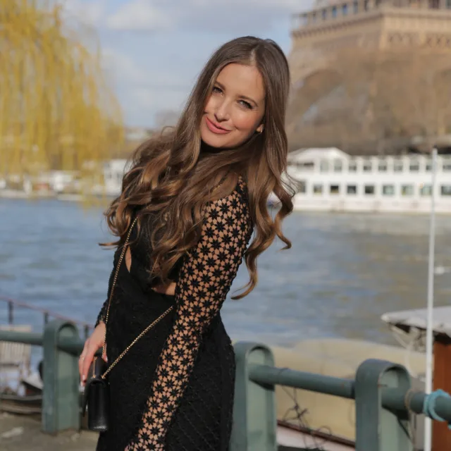 Travel Advisor Eileen Maralian with a black patterned dress in front of the Eiffel tower.