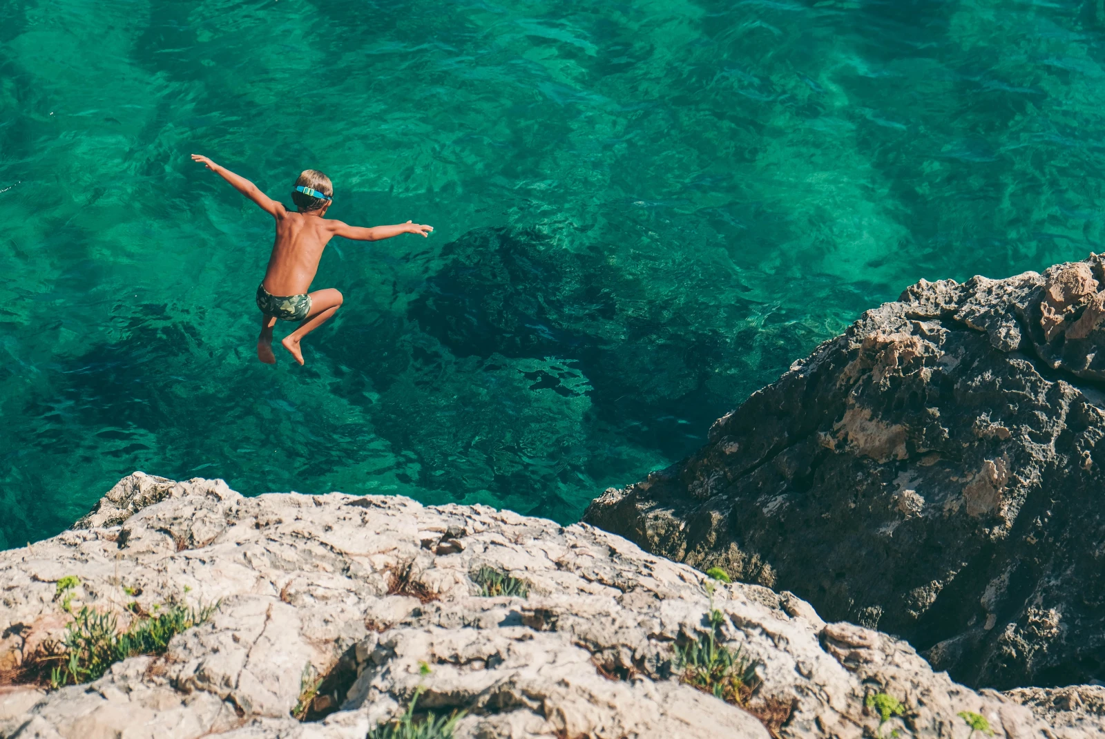A boy jumping into the sea in Hvar. 
