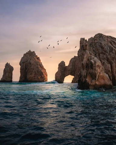Rock formations in the ocean during a sunset.