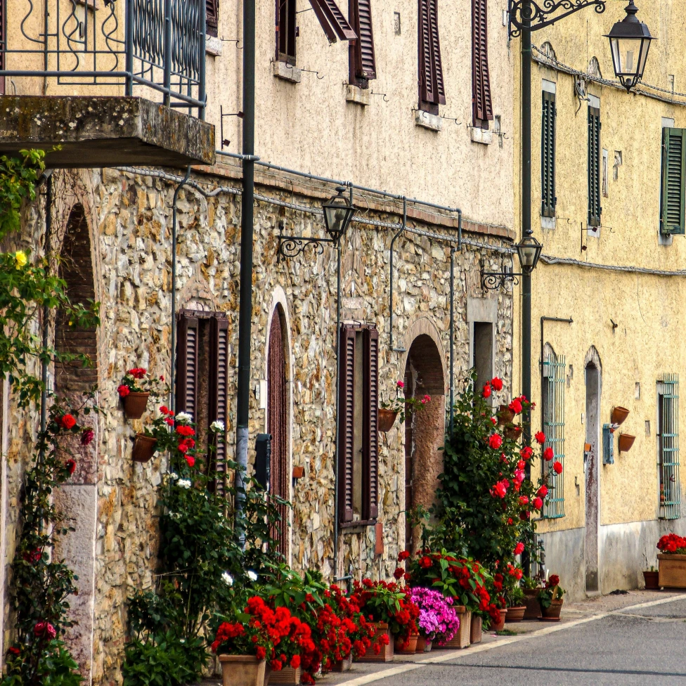 An Italian building with red and pink flowers. 