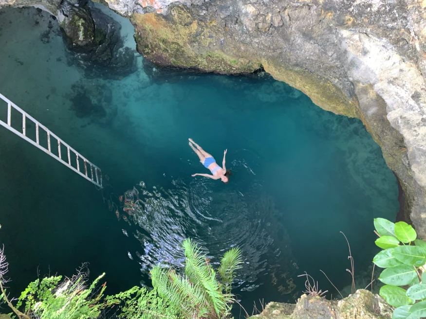 View from above of a woman swimming in the Blue Hole in Jamaica