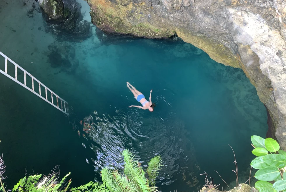 View from above of a woman swimming in the Blue Hole in Jamaica