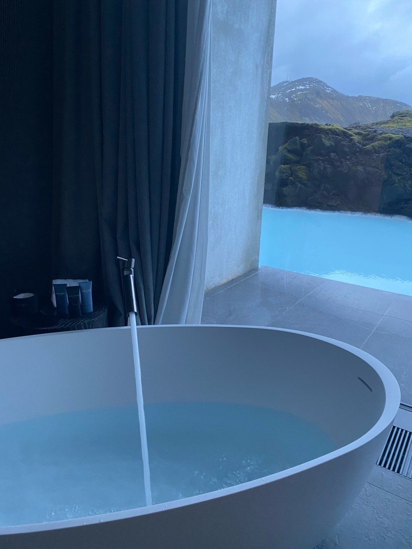 A white bathtub being filled with water
