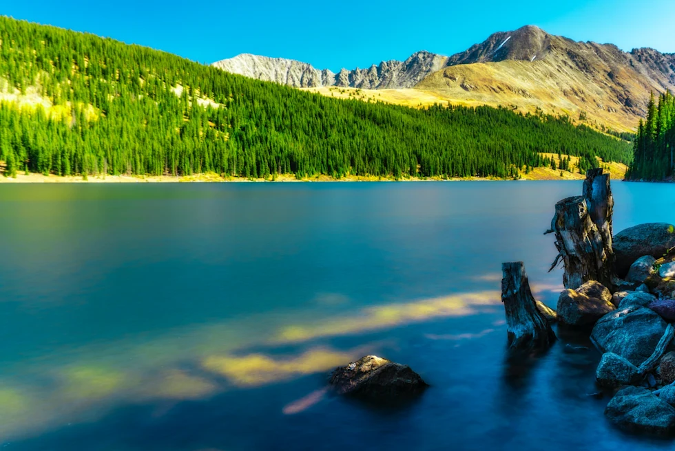 A lake in Vail with green mountains.