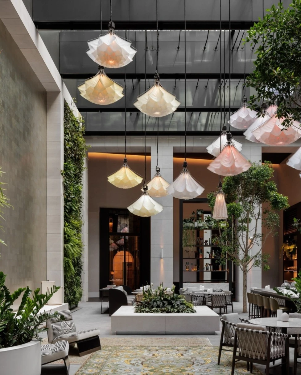long white hanging lights in an airy lush courtyard