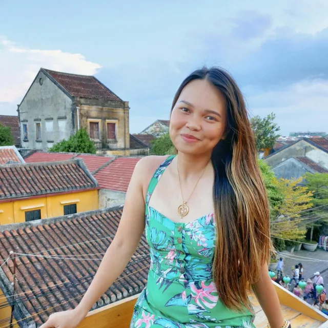 Travel Advisor Jastine Cleene with a floral dress and houses in the background.