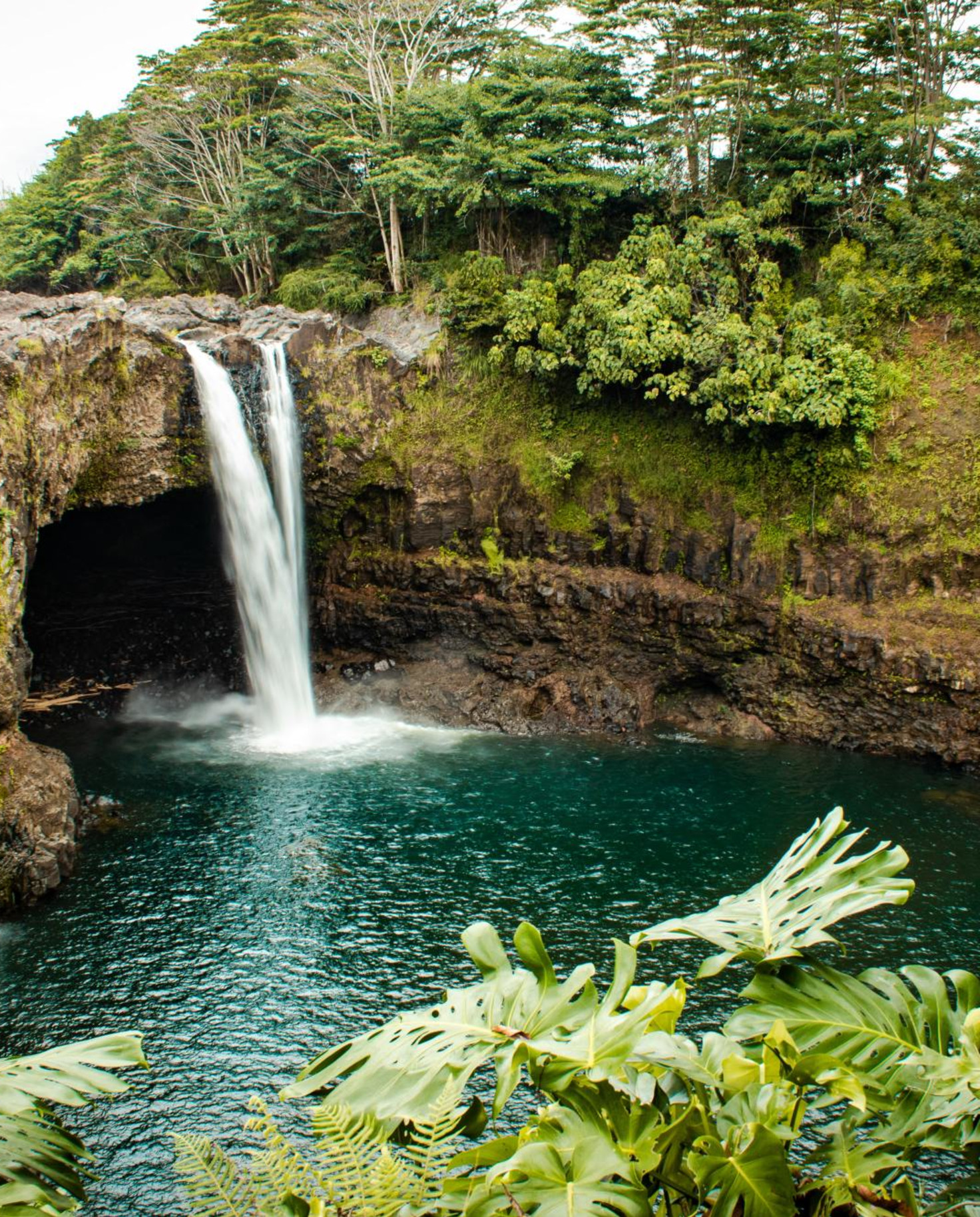 Private swimming hole surrounded by jungle with waterfall in Hilo, Hawaii.
