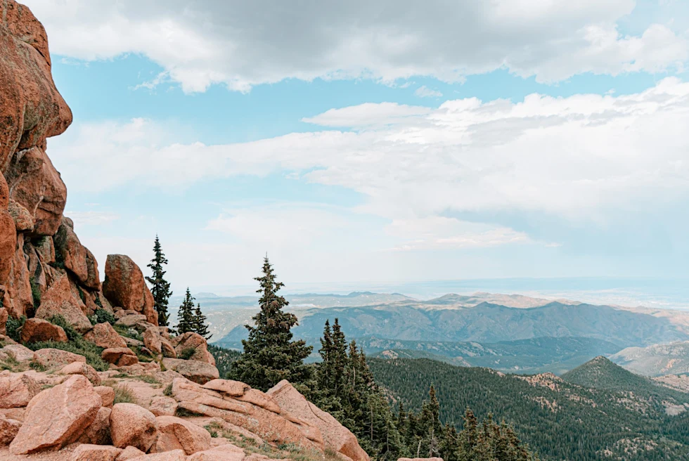 red-rock mountain perch overlooking a lush valley