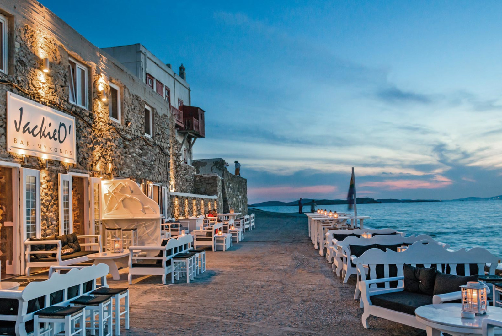 chairs and tables outside next to stone building