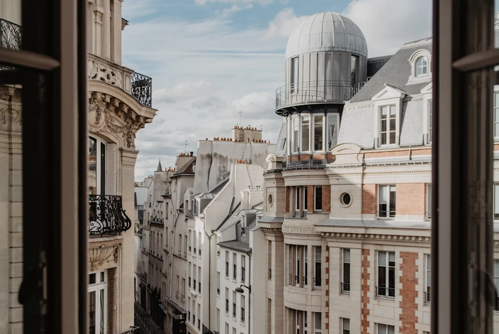 View outside of a window in Paris looking out to the street on a bright day.