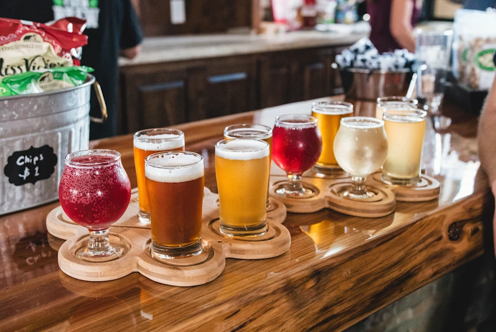 Glasses of beer, wine and drinks on a wooden bar