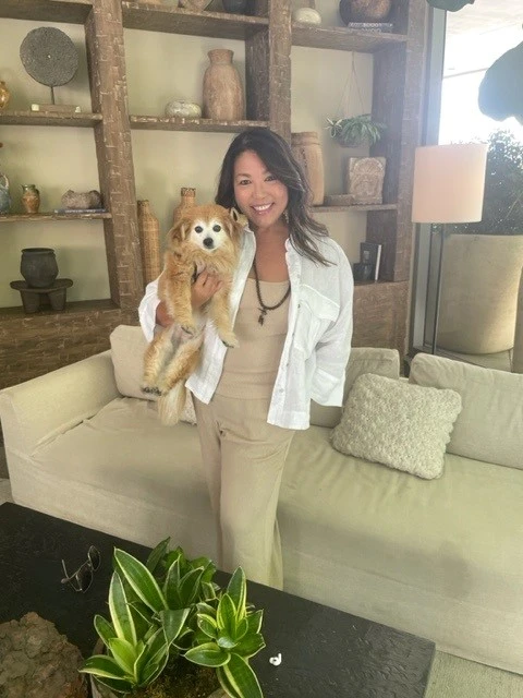 Wendi Yip in a white jacket carrying her adorable dog