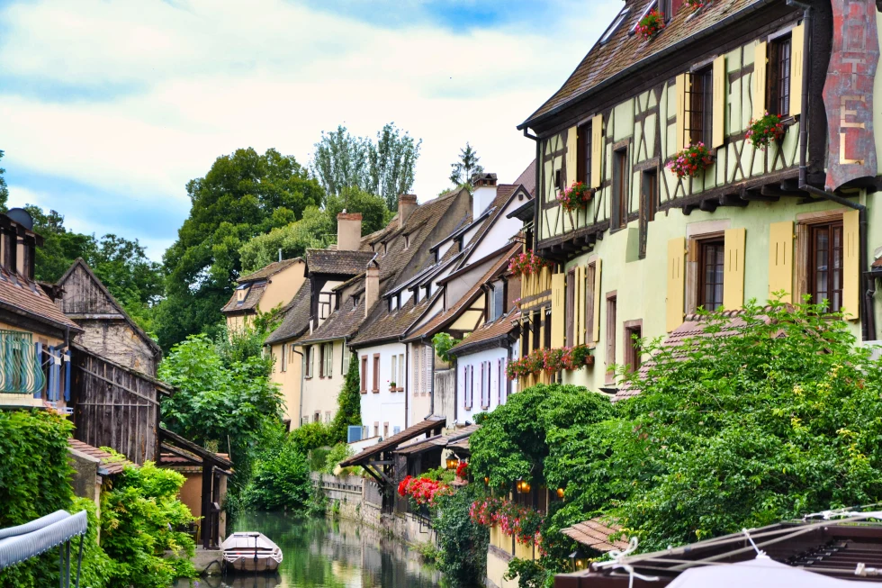 Alsace street with a river and houses with flowers. 