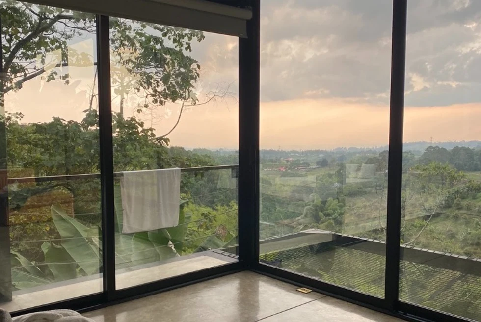 glass room over green landscape at sunset