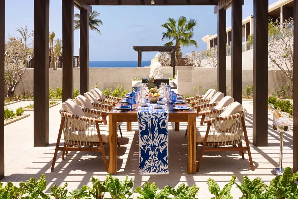 wooden table with chairs outdoors next to palm trees