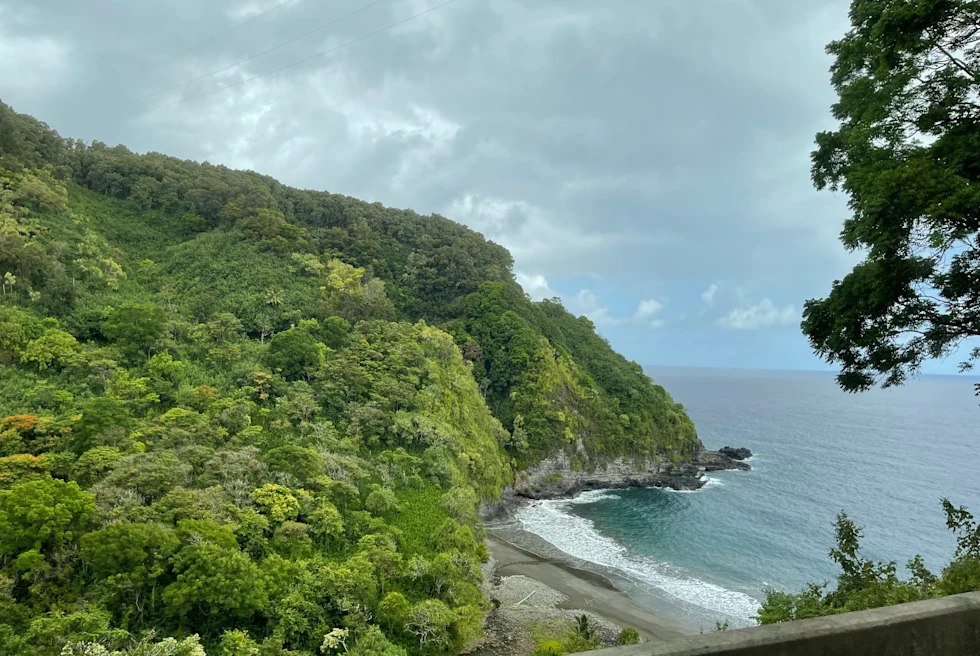 Green mountains next to body of water with cloudy skies during daytime