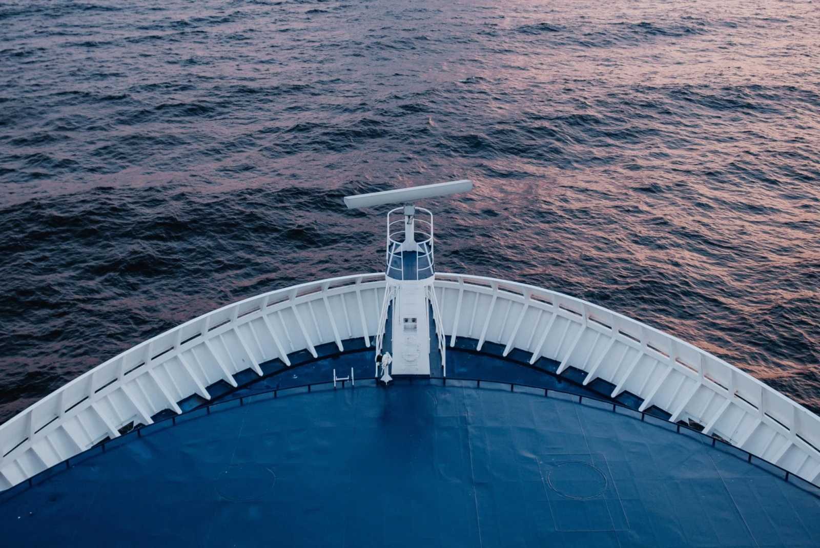 blue cruise ship bow overlooking the sea at dusk