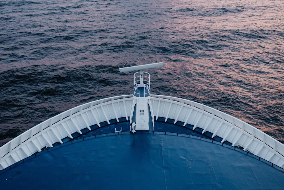 blue cruise ship bow overlooking the sea at dusk
