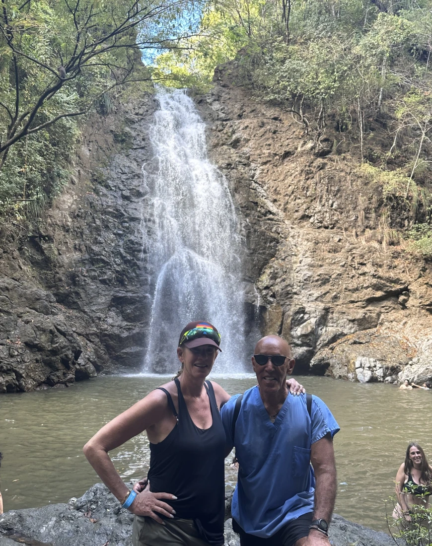 Couple posing in front of a waterfall