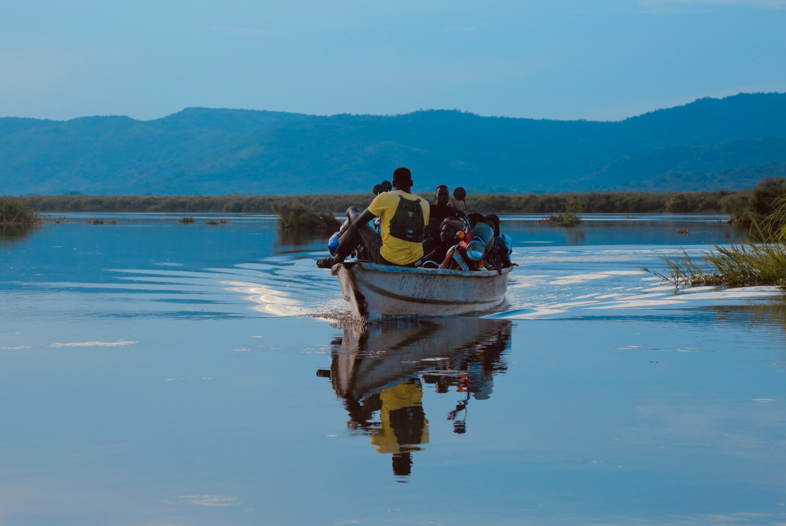 People ride in boat on the water in Uganda