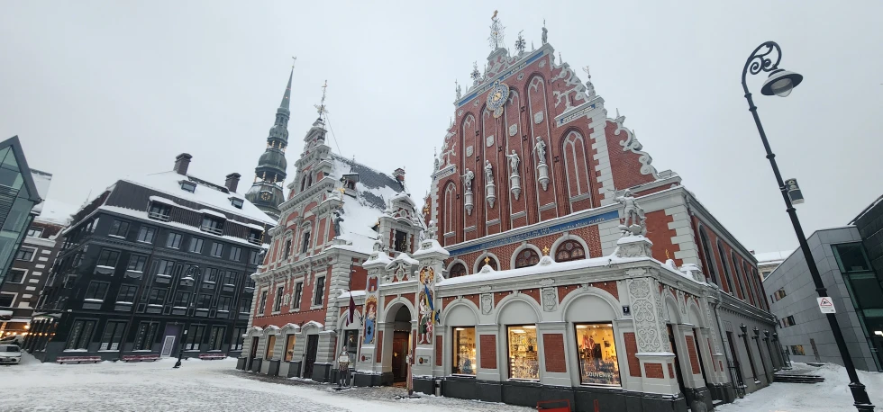 A picture of the building in Latvia in the daytime covered with snow.