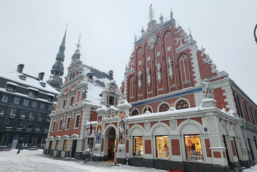 A picture of the building in Latvia in the daytime covered with snow.