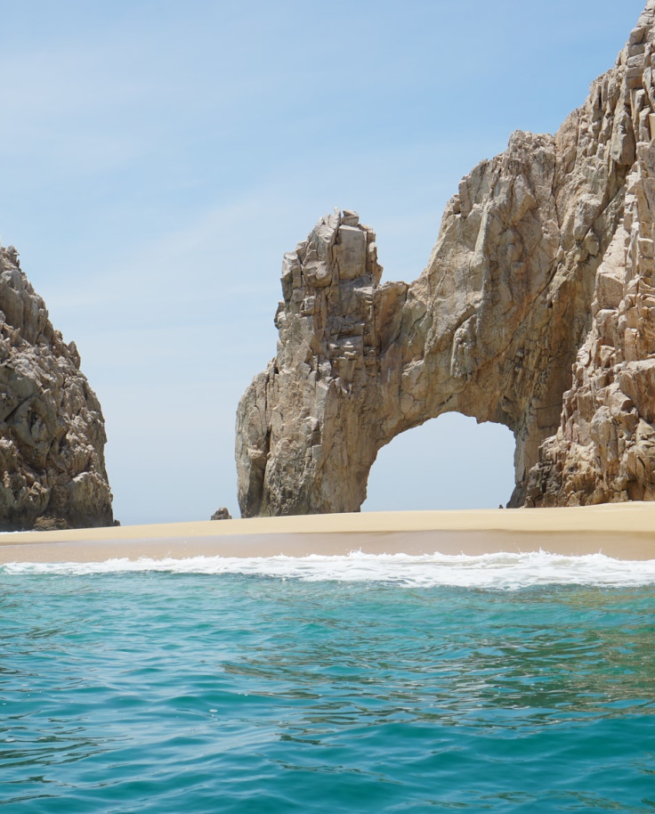 beachside cliffs with blue water and tan san in los cabos mexico