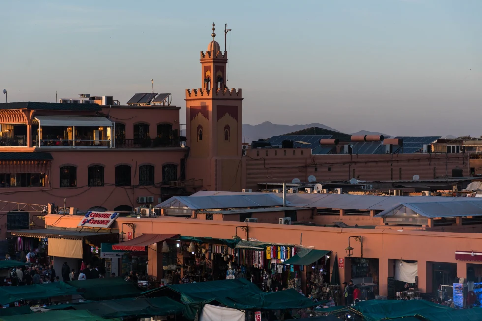 square in walled desert city with mosque during golden hour