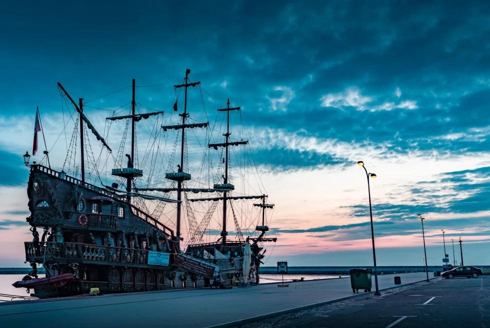 large old ship docked at sunset