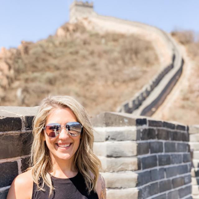 Fora travel agent Lauren Martin wearing black shirt next stone wall