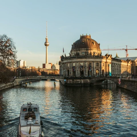 Boat in body of water next to buildings during daytime