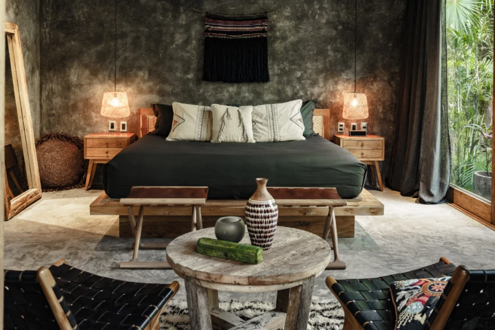 a bed with charcoal-colored bedding near artisanal artwork
