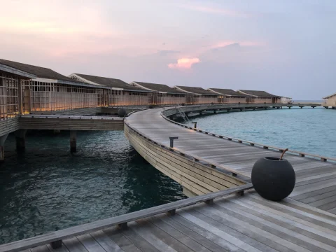 wooden overwater pathway leading to various bungalows