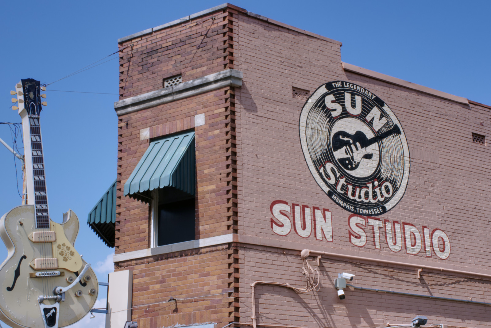 building with sign and large guitar during daytime