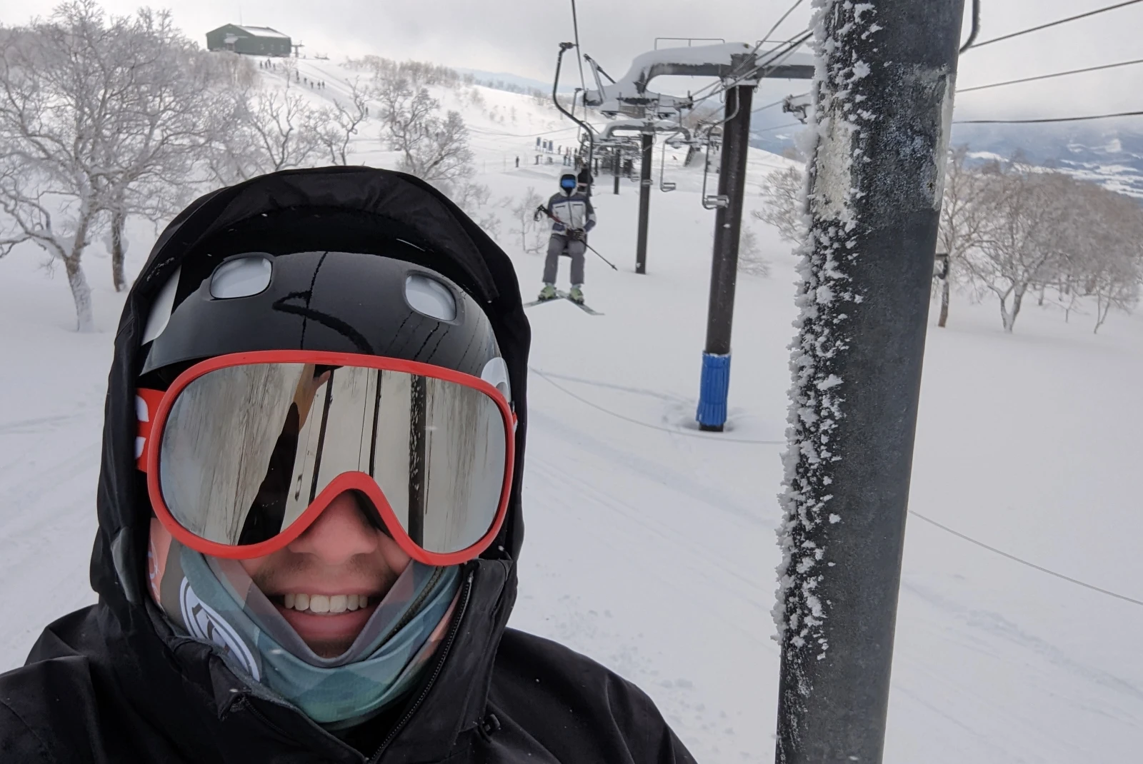 A person in snow mask on a ski lift.