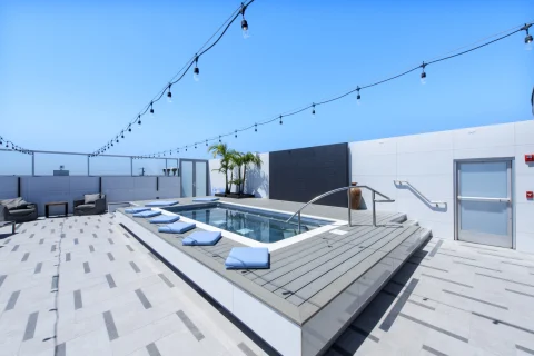 A hotel's rooftop pool, under a clear, blue sky. 