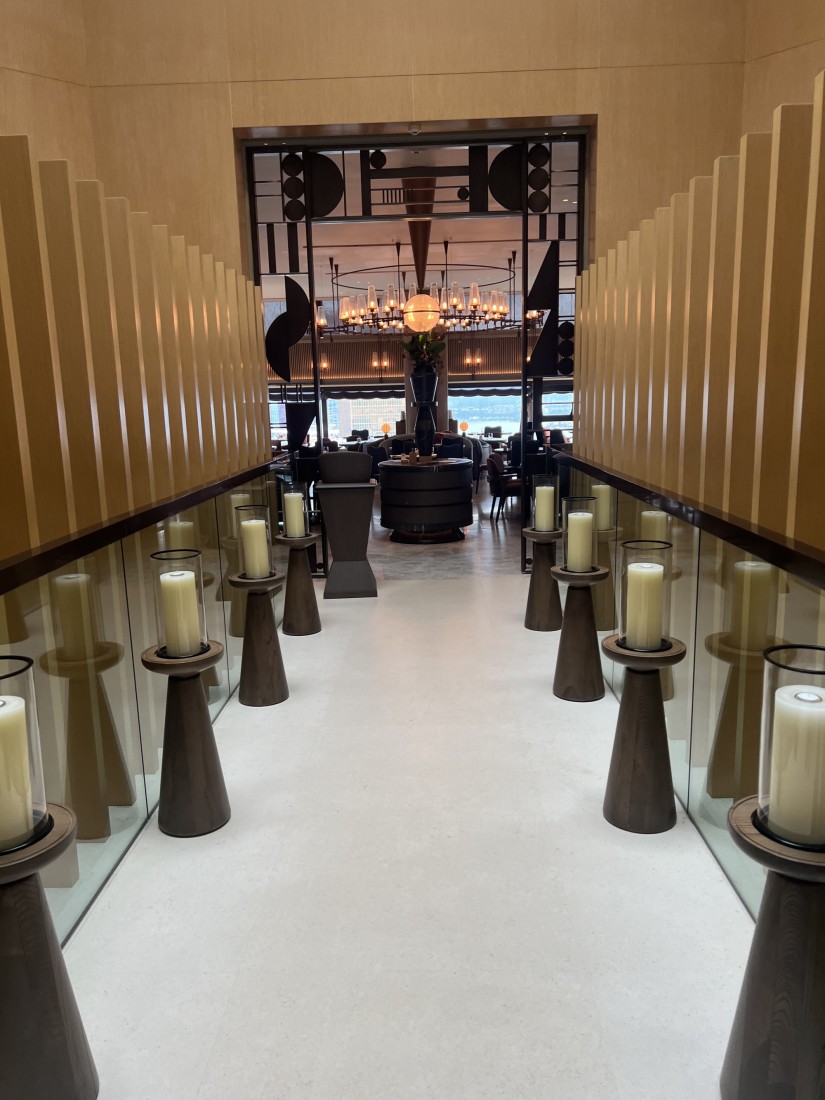 A hallway lined with life-size candles leading to the hotel bar / lounge.
